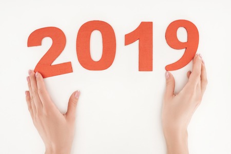 cropped view of woman adjusting 2019 date made of red numbers isolated on white