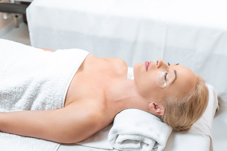 Beautiful woman lying with eye patches in spaの写真素材