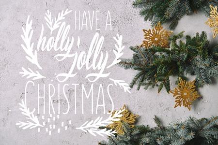 cropped image of handmade Christmas tree with snowflakes hanging on grey wall with have a holly jolly christmas inspiration