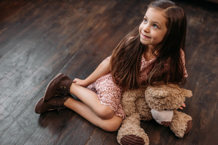 adorable little child sitting on floor with teddy bearの写真素材
