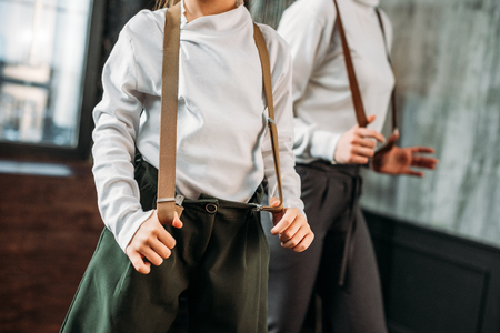 cropped shot of mother and daughter in stylish clothing with suspendersの写真素材