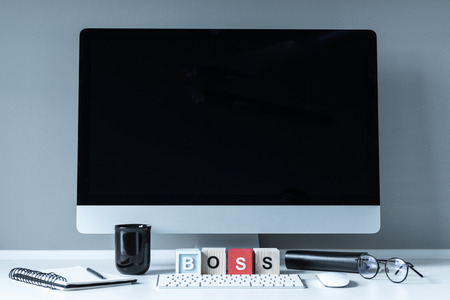 computer and wooden cubes with word Boss on white tabletopの写真素材