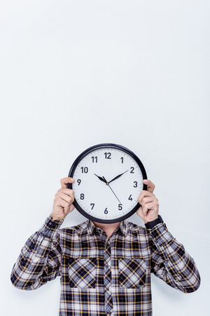 Clock in male hands over his face  isolated on whiteの写真素材