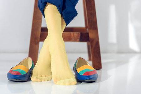 Cropped view of female legs in yellow socksの写真素材