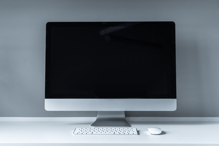 computer with black screen and keyboard on tableの写真素材