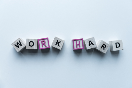 top view of wooden cubes with words Work Hard on blue surface