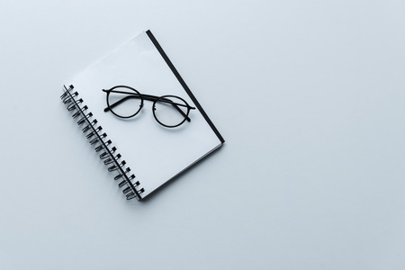 top view of glasses on open white notebook isolated on whiteの写真素材