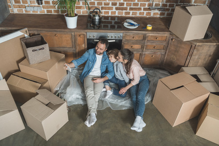 high angle view of happy family taking selfie with smartphone while moving home
