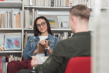 african american girl looking at man in library