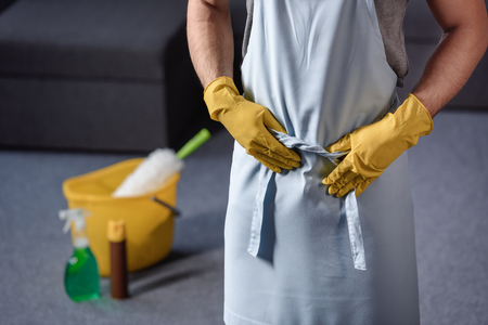 cropped image of man in rubber gloves touching apronの写真素材