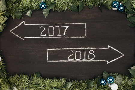 top view of 2017, 2018 year signs with christmas decorations around on dark wooden surfaceの写真素材