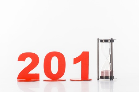 close up view of sand clock and 2018 year sign isolated on white