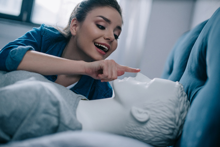 close up view of excited woman with mannequin in bed, loneliness conceptの写真素材