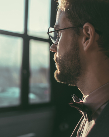 close-up view of bearded young man in eyeglasses and bow tie looking awayの写真素材