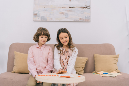 kids preparing greeting for mothers day at home on couchの写真素材