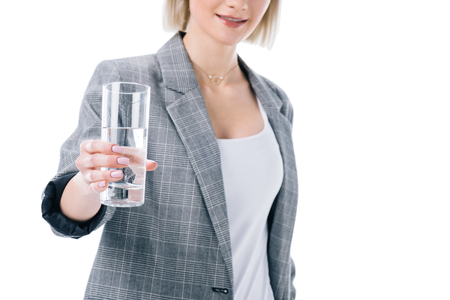 cropped view of woman holding glass of water, isolated on whiteの写真素材