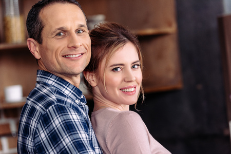 side view of happy couple looking at camera at homeの写真素材