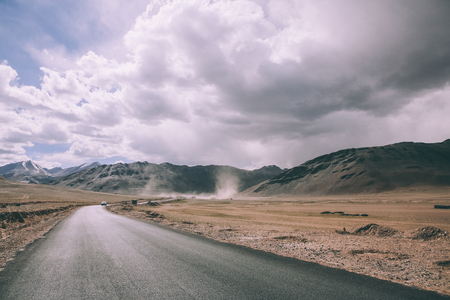 empty asphalt road in mountain valley and cloudy sky in Indian Himalayas, Ladakh regionの写真素材