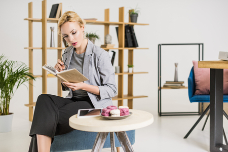 portrait of focused businesswoman reading book in officeの写真素材