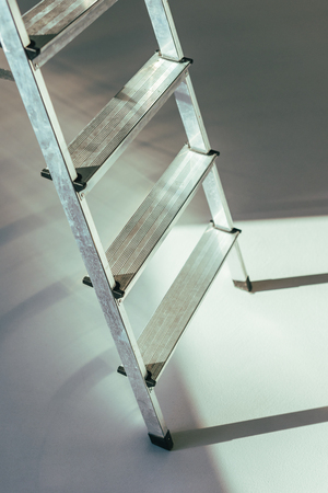 close-up view of metal stepladder in studio on greyの写真素材