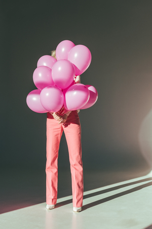 stylish woman holding pink balloons for holidayの写真素材