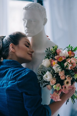 young woman with bouquet of flowers hugging layman doll, perfect relationship dream concept