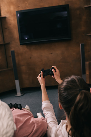 back view of woman with manikin near by playing video game at home, loneliness conceptの写真素材