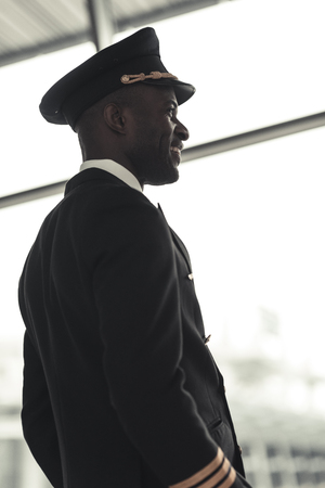handsome young pilot looking away at airportの写真素材