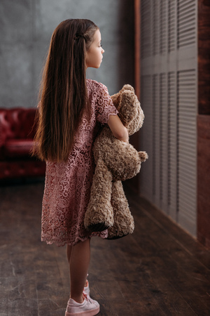 adorable little child holding teddy bear at loft apartmentsの写真素材