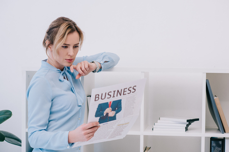 concentrated businesswoman reading newspaper at officeの写真素材