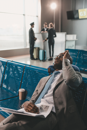 businessman sleeping at airport lobby while waiting for flightの写真素材