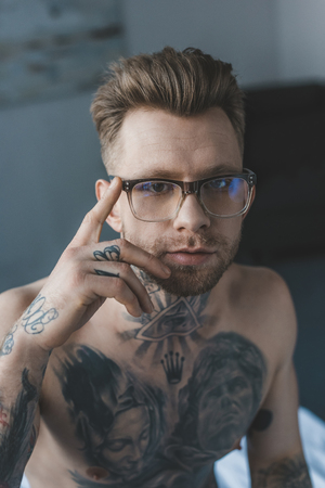 portrait of handsome tattooed man in stylish eyeglassesの写真素材