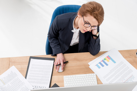 overhead view of tired businesswoman looking at computer screen at workplace in officeの写真素材
