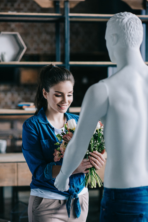 young woman pretending to receive flowers from layman doll, perfect relationship dream conceptの写真素材
