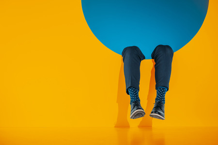 cropped image of male legs in orange round aperture