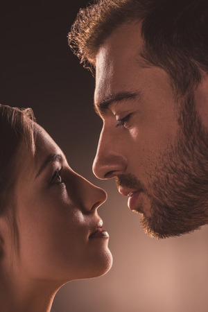 passionate couple looking at each other, on brownの写真素材