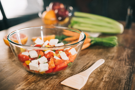 glass bowl with salad and wooden spatula on tableの写真素材