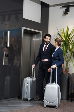 business people with luggage waiting for elevator at hotel togetherの写真素材