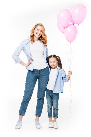 smiling mother and daughter with pink balloons isolated on whiteの写真素材