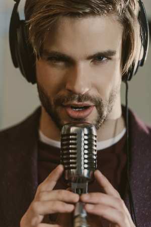 close-up portrait of handsome young singer performing song and looking at cameraの写真素材