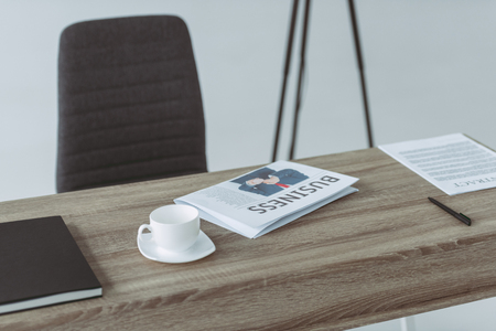 cup and business newspaper on table on grayの写真素材