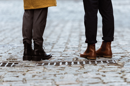 cropped image of female and male legs in autumn shoesの写真素材