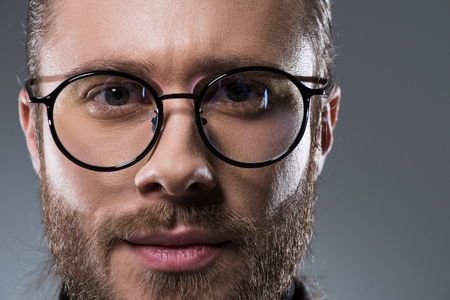 Portrait of handsome bearded man in glasses, isolated on grayの写真素材