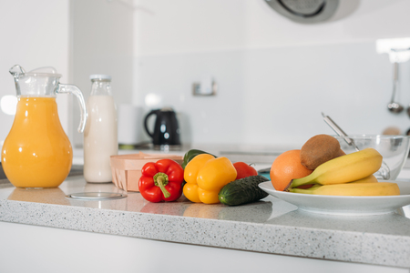 fruits, vegetables and orange juice with milk on kitchen tableの写真素材