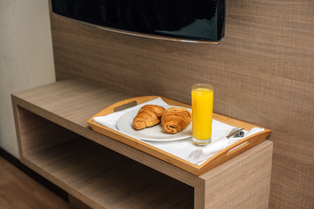 croissants and orange juice on wooden trayの写真素材