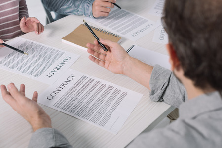 partial view of middle aged people working with papers togetherの写真素材