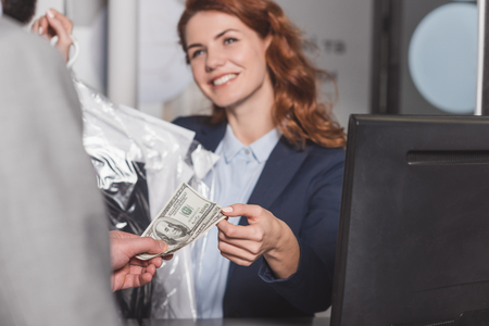 dry cleaning manageress taking cash for orderの写真素材