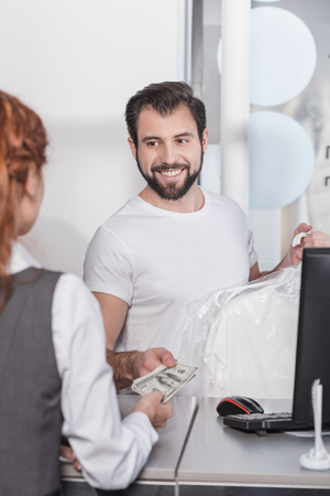 dry cleaning manager taking money for work from customerの写真素材