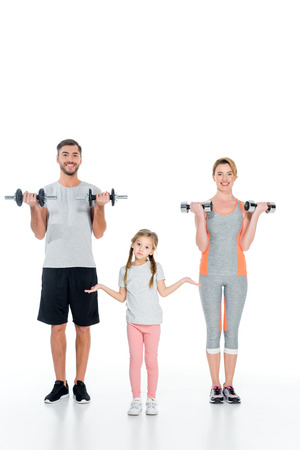sportive parents and daughter with dumbbells isolated on whiteの写真素材