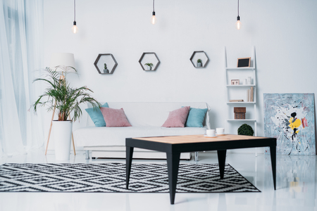 wooden table and sofa with pillows in roomの写真素材